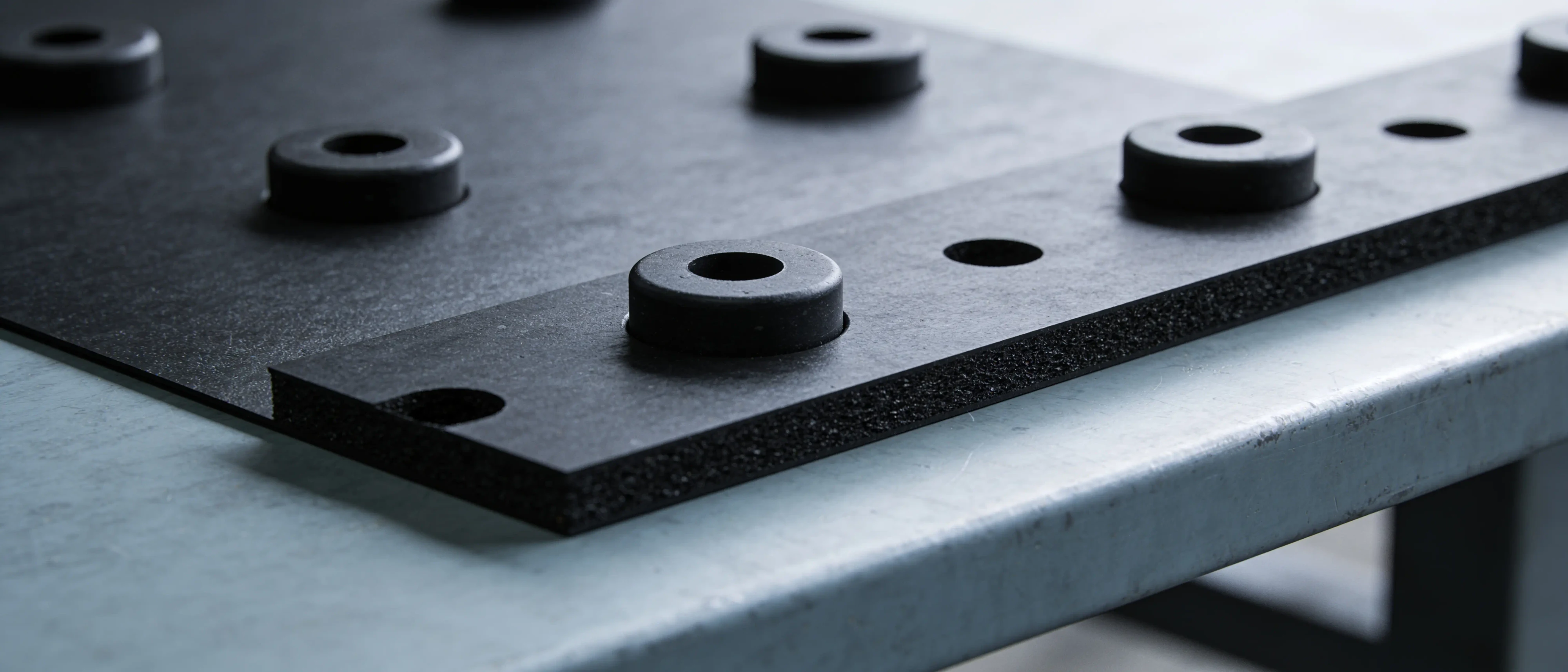 Gestanzte schwarze Gummischeiben auf einem Streifen aus schwarzem EPDM