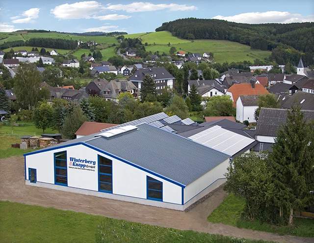 Luftbild der Fertigungshalle der Winterberg & Knapp GmbH mit Firmenschriftzug, dahinter Oberschledorn